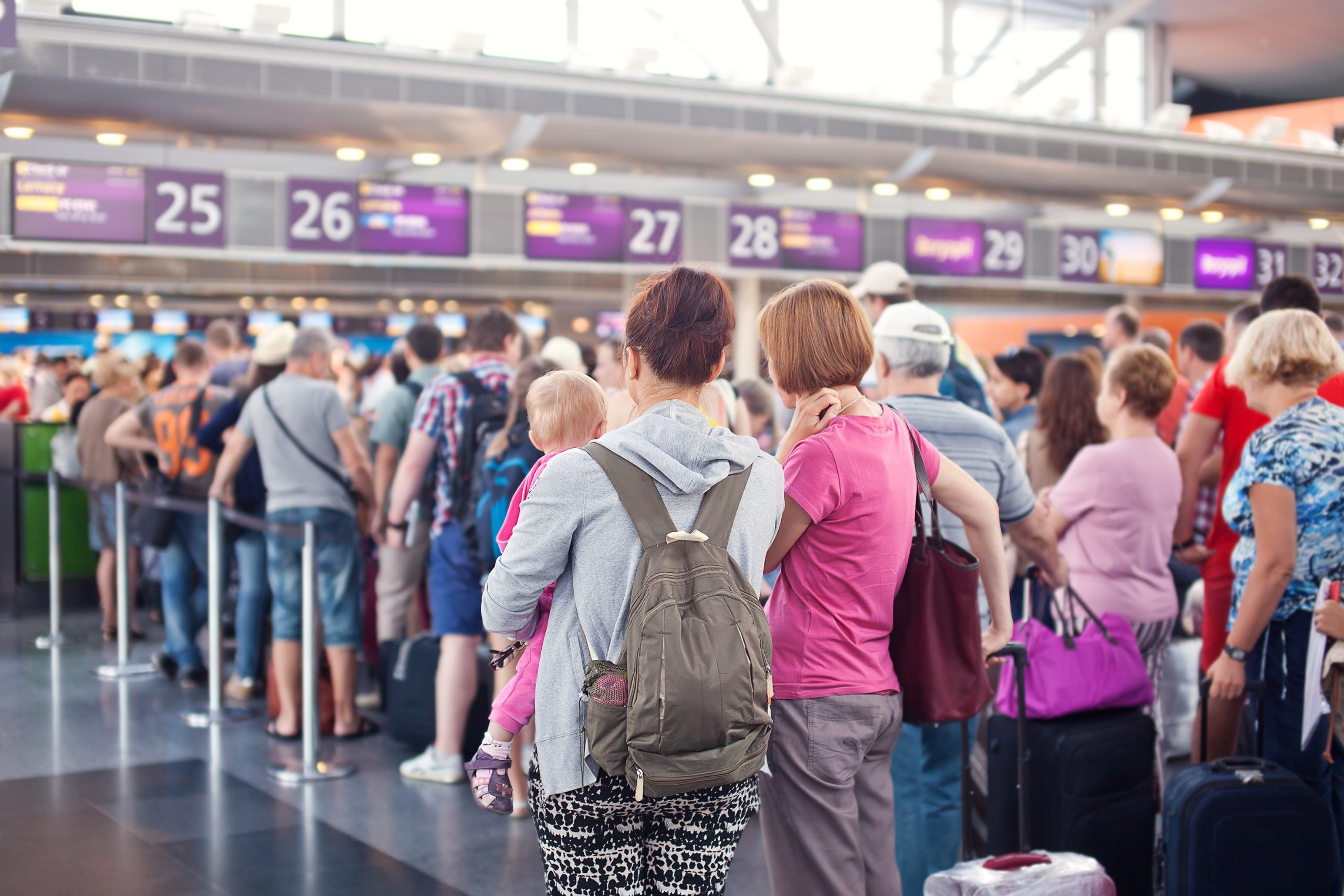 Mensen in de rij bij de check-in op het vliegveld.